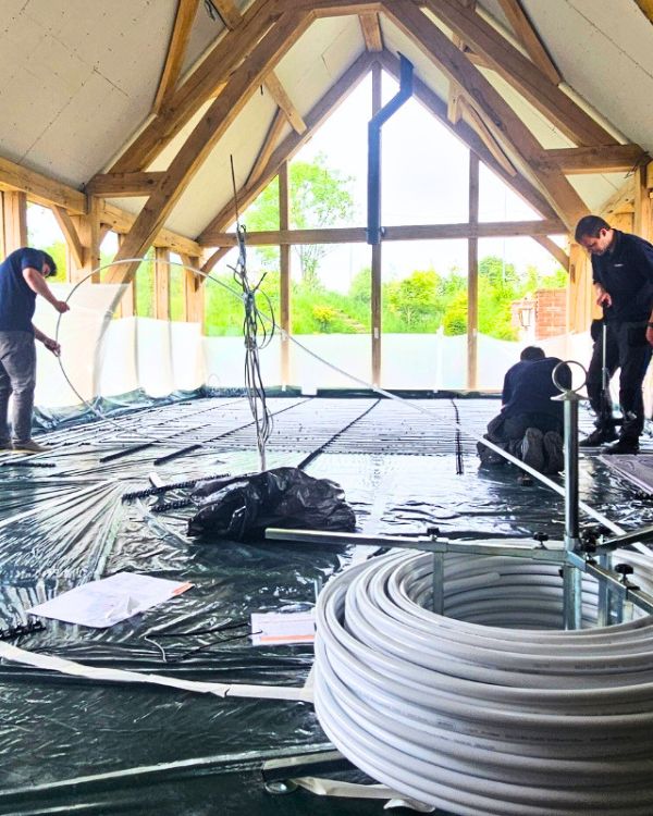 Heating engineers installing underfloor heating in large home